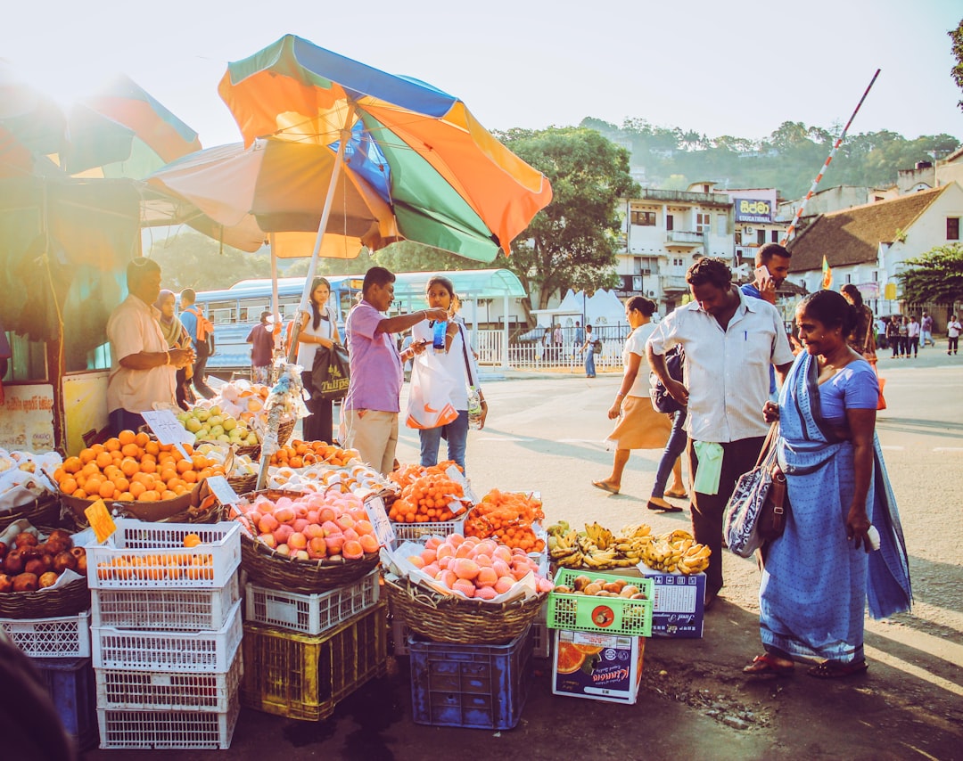 people walking on street with fruit display during daytime