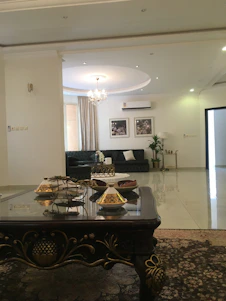 Elegant dark green and gold-themed living room with handcrafted furniture and stylish decor accents.