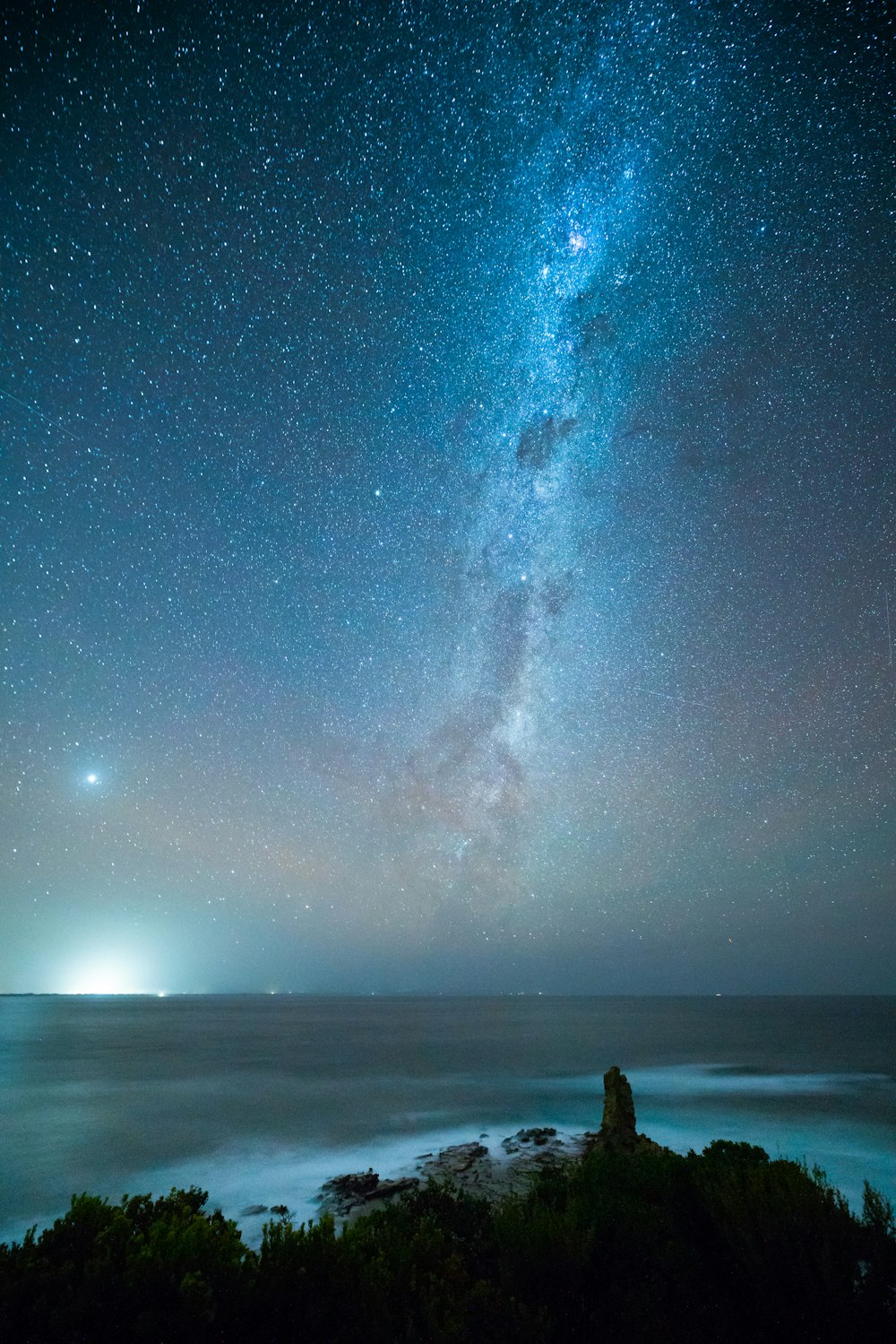 person standing on beach under starry night