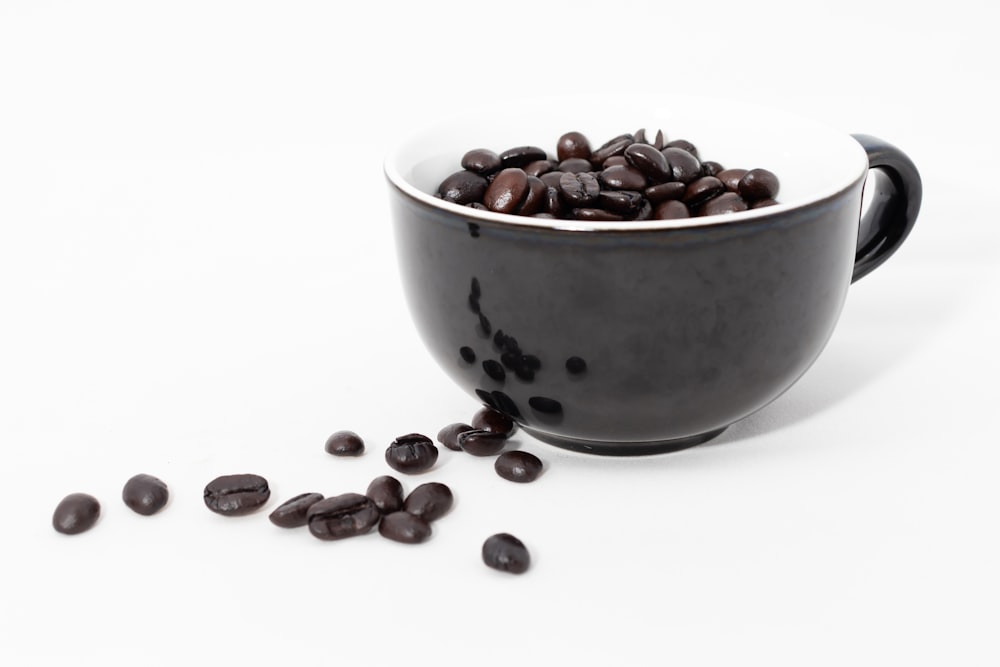 brown and black round fruits in white ceramic bowl