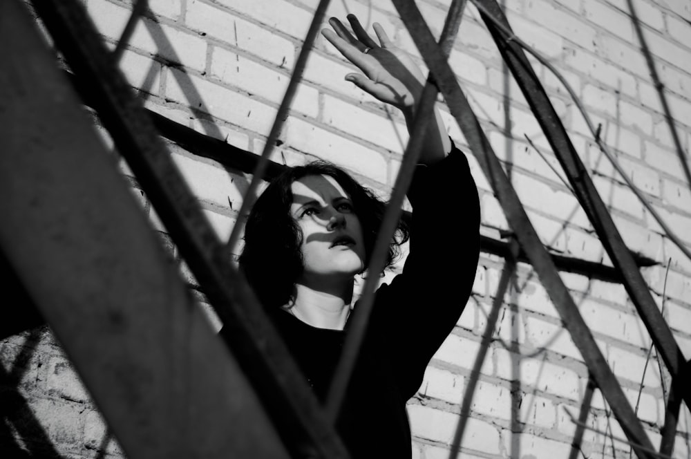 woman in black long sleeve shirt standing in front of metal fence