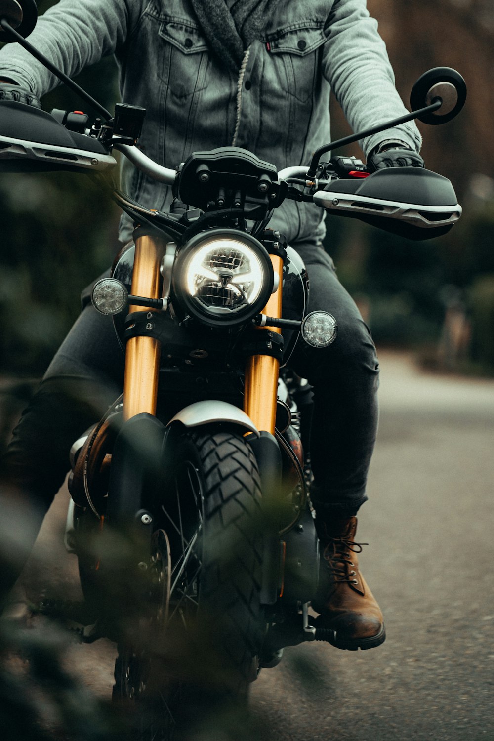 Persona en chaqueta de cuero negro montando en motocicleta negra