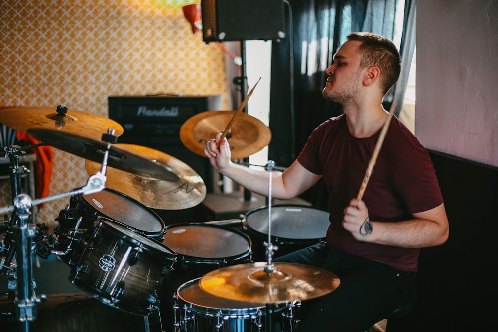 man in black crew neck t-shirt playing drum