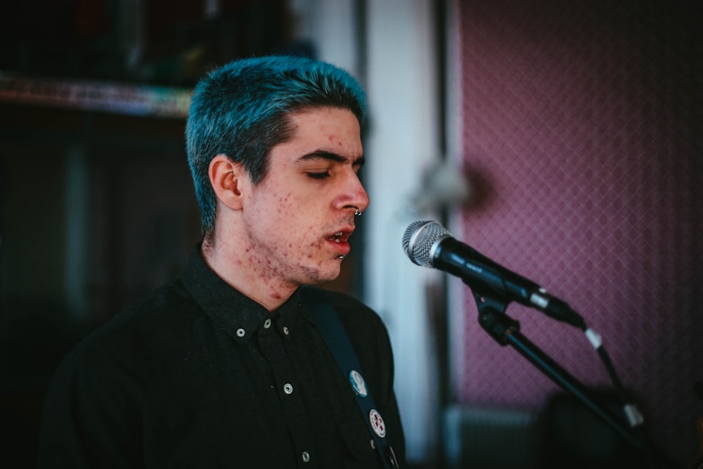 man in black button up shirt standing in front of microphone