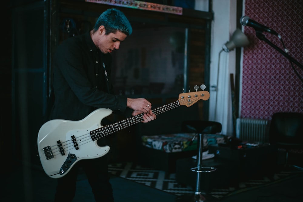 man in black jacket playing electric guitar