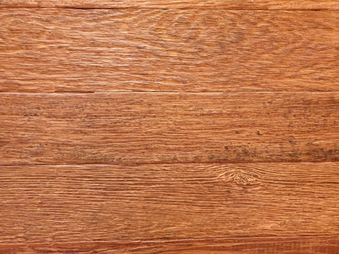 Detailed texture of restored wood grain with warm brown tones.