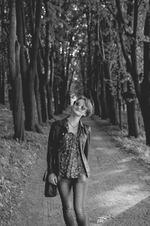 Sunlit woodland path with a model wearing a burnt amber boho jacket blending into the natural surroundings.