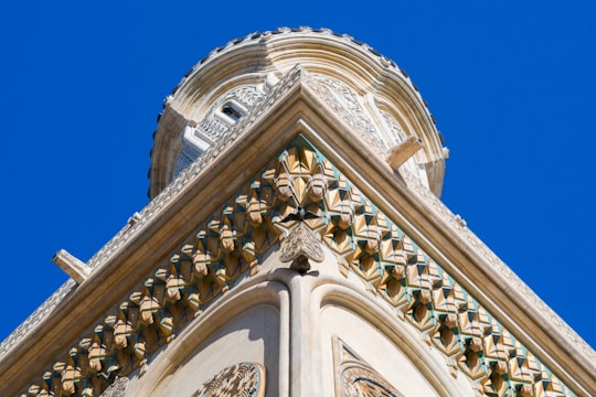 white concrete building under blue sky during daytime in Argeș Monastery Romania