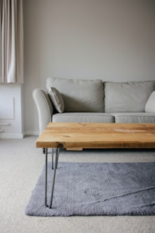 brown wooden table beside white couch