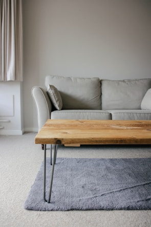 brown wooden table beside white couch