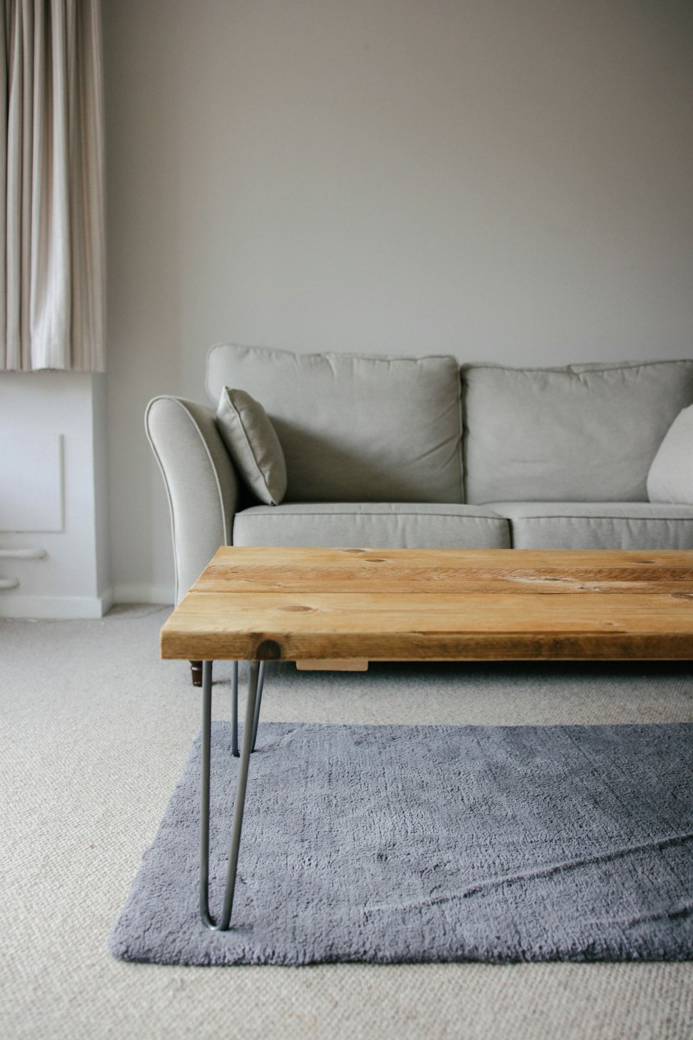 Mesa de madera marrón junto a sofá blanco