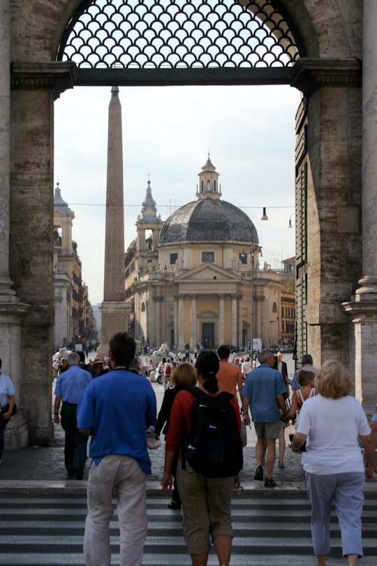 people walking near brown concrete building during daytime in Piazza del Popolo Italy