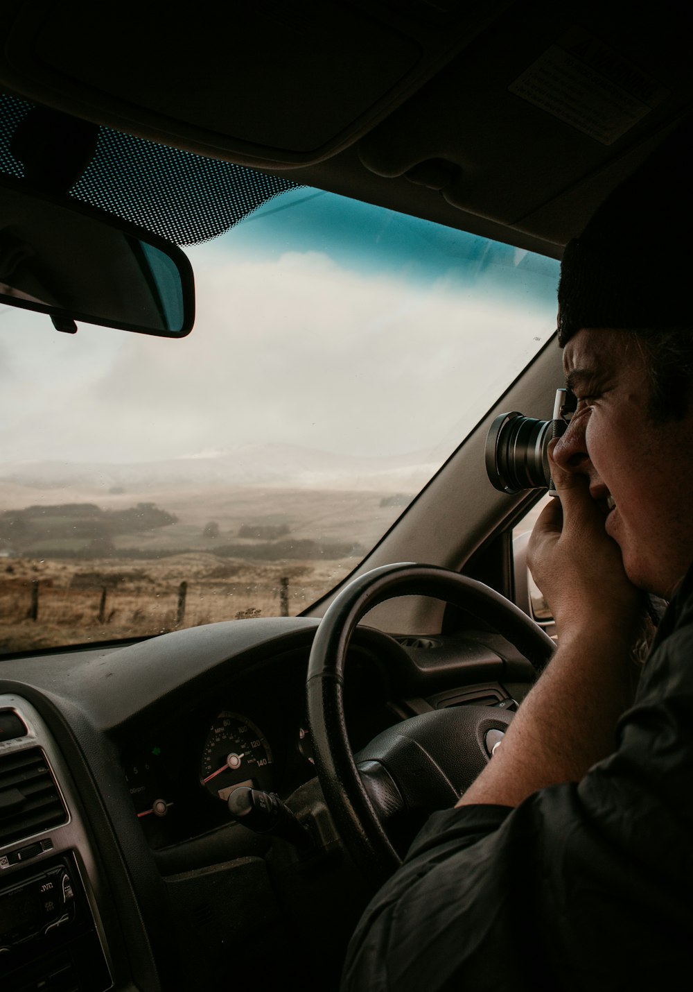 man in gray shirt driving car during daytime