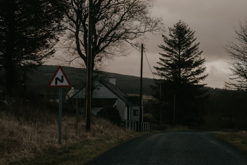 gray concrete road near trees and houses during daytime