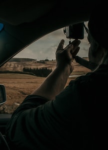 A vibrant scene of a car influencer filming a road trip with a scenic backdrop.