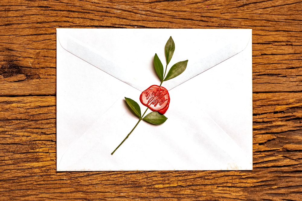red rose on white envelope