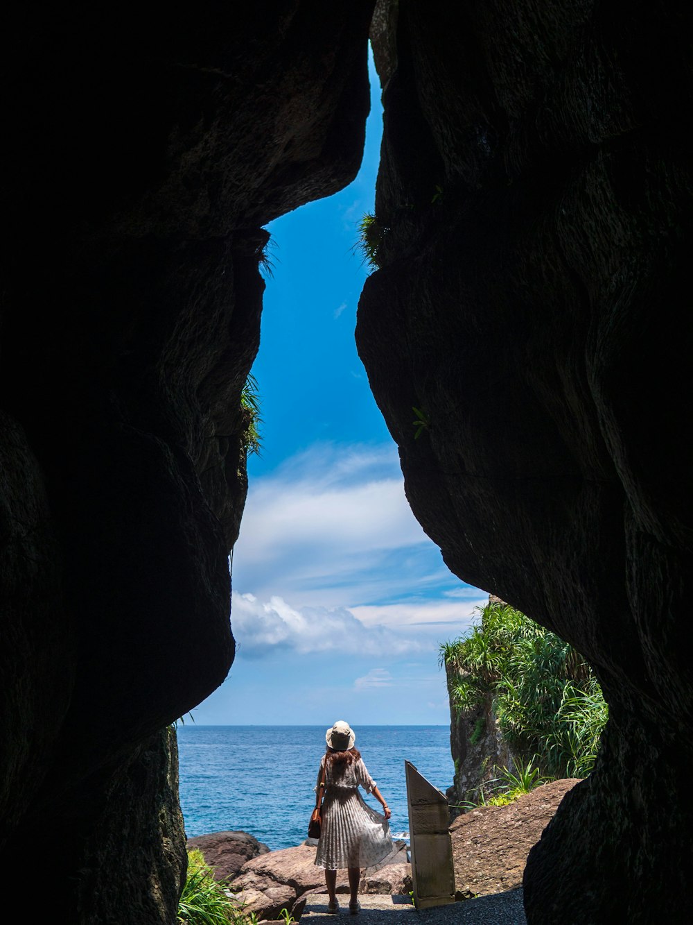 woman in white shirt sitting on rock formation during daytime