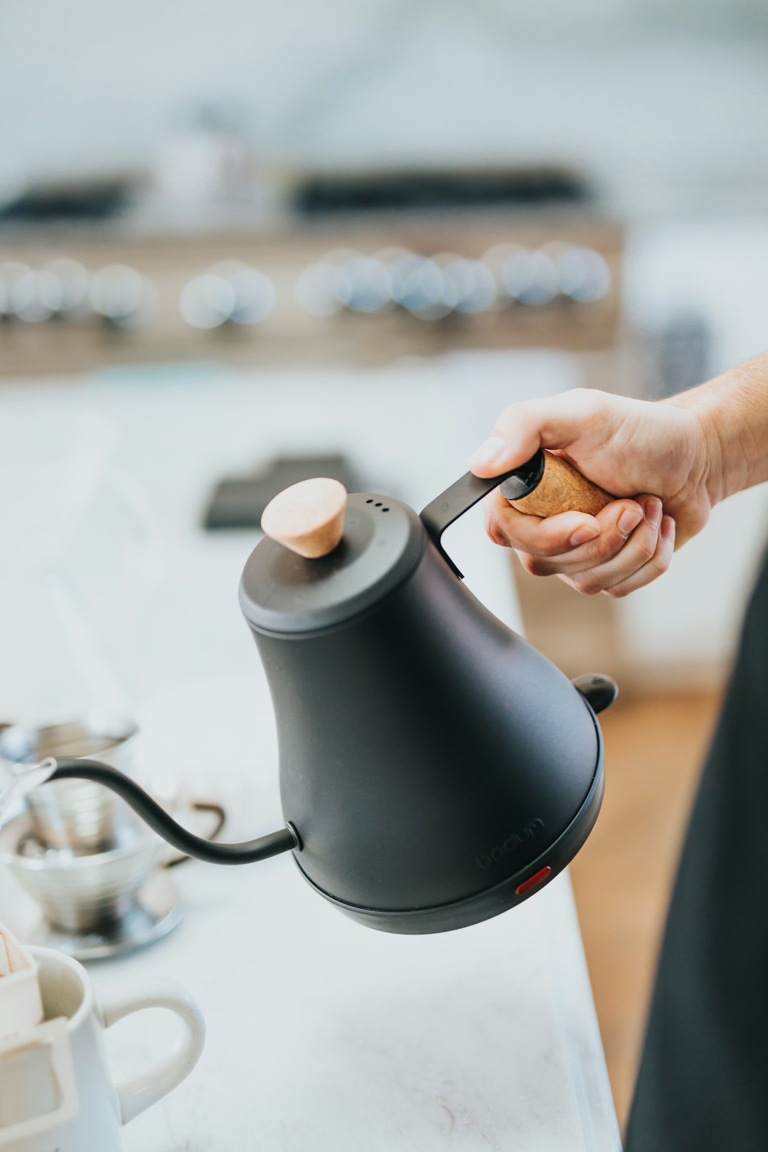 person pouring water on black ceramic mug