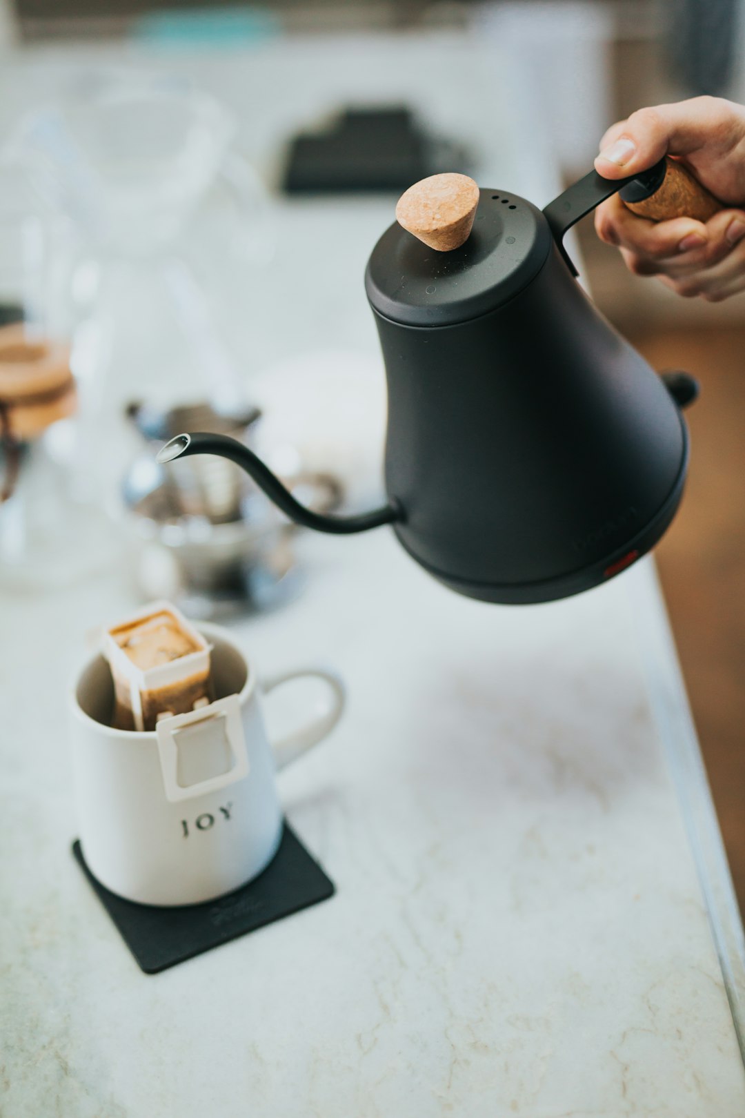 person pouring coffee on white ceramic mug