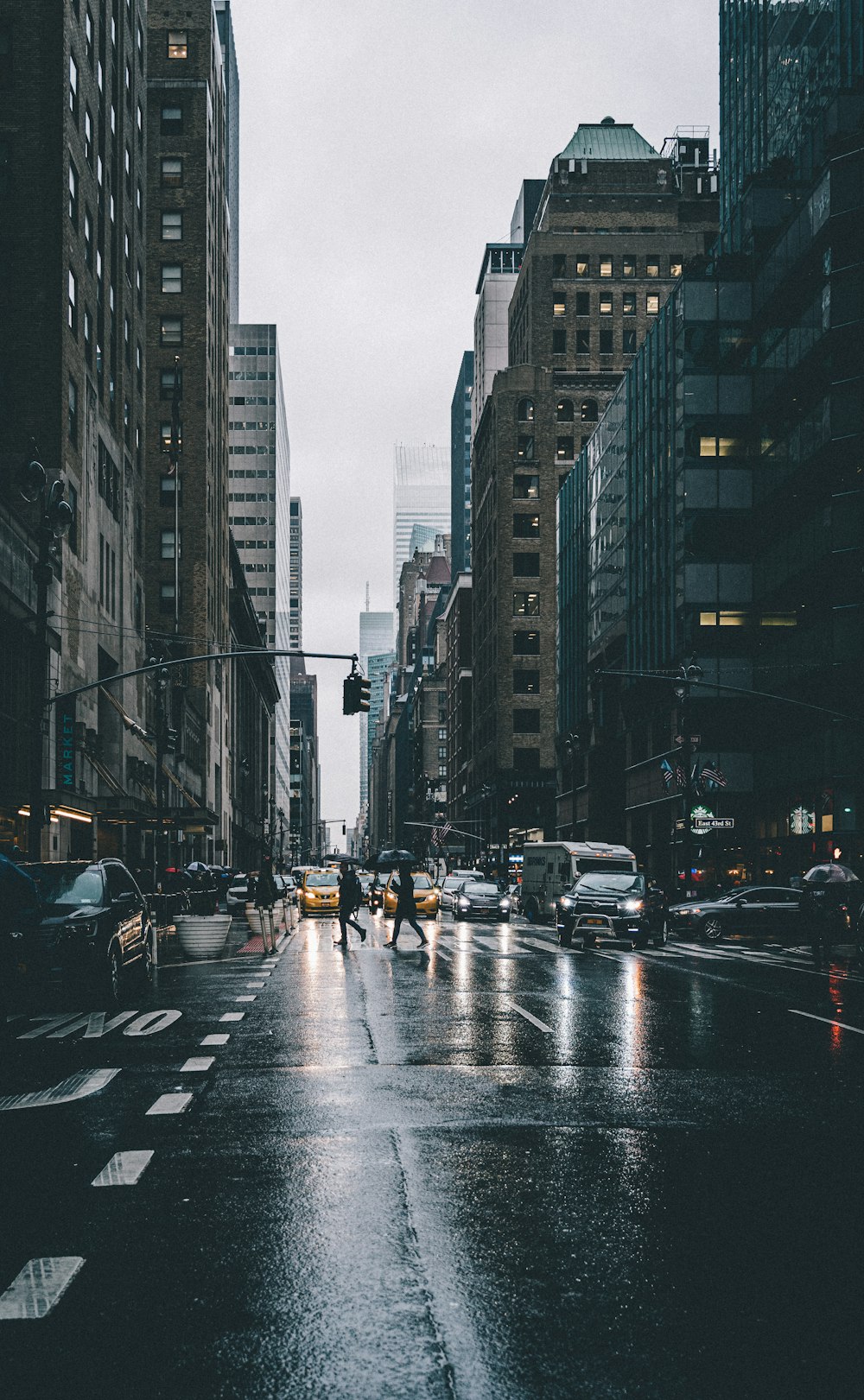 cars on road between high rise buildings during daytime