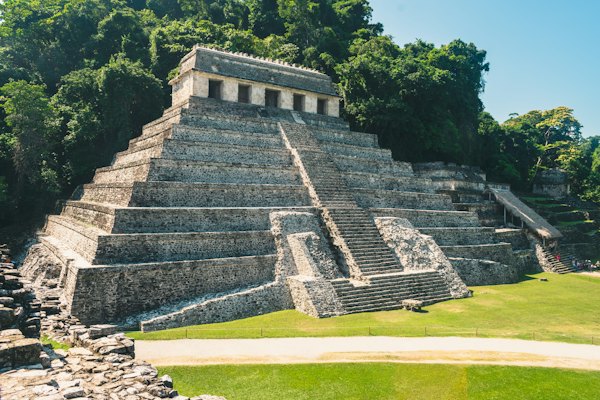 Gray concrete building near green grass field during daytime — Palenque, Mexico