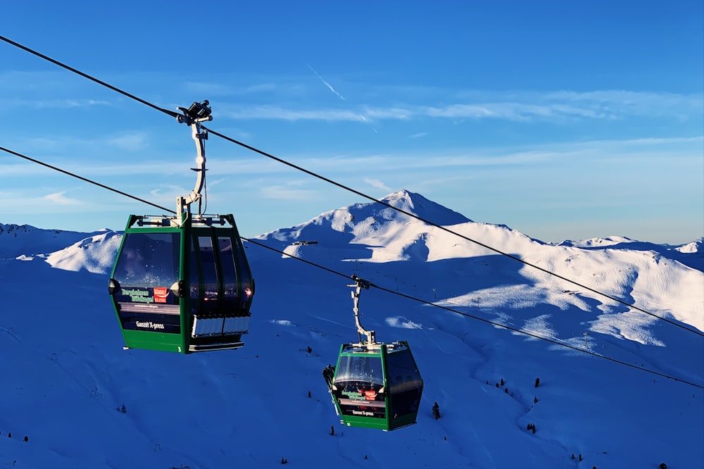 green cable car over snow covered mountain during daytime