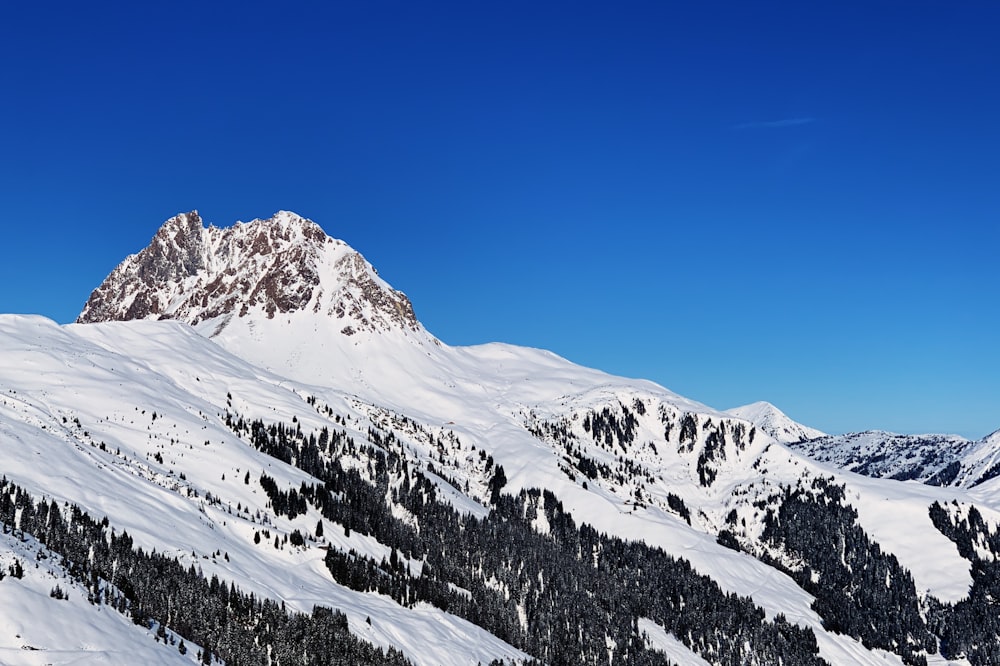 montanha coberta de neve sob o céu azul durante o dia