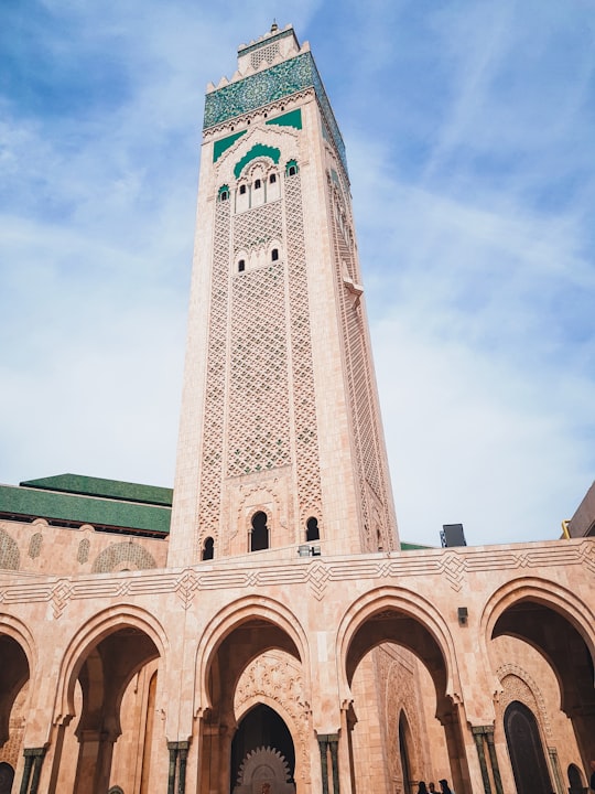 white concrete building under blue sky during daytime in Hassan II Mosque Morocco