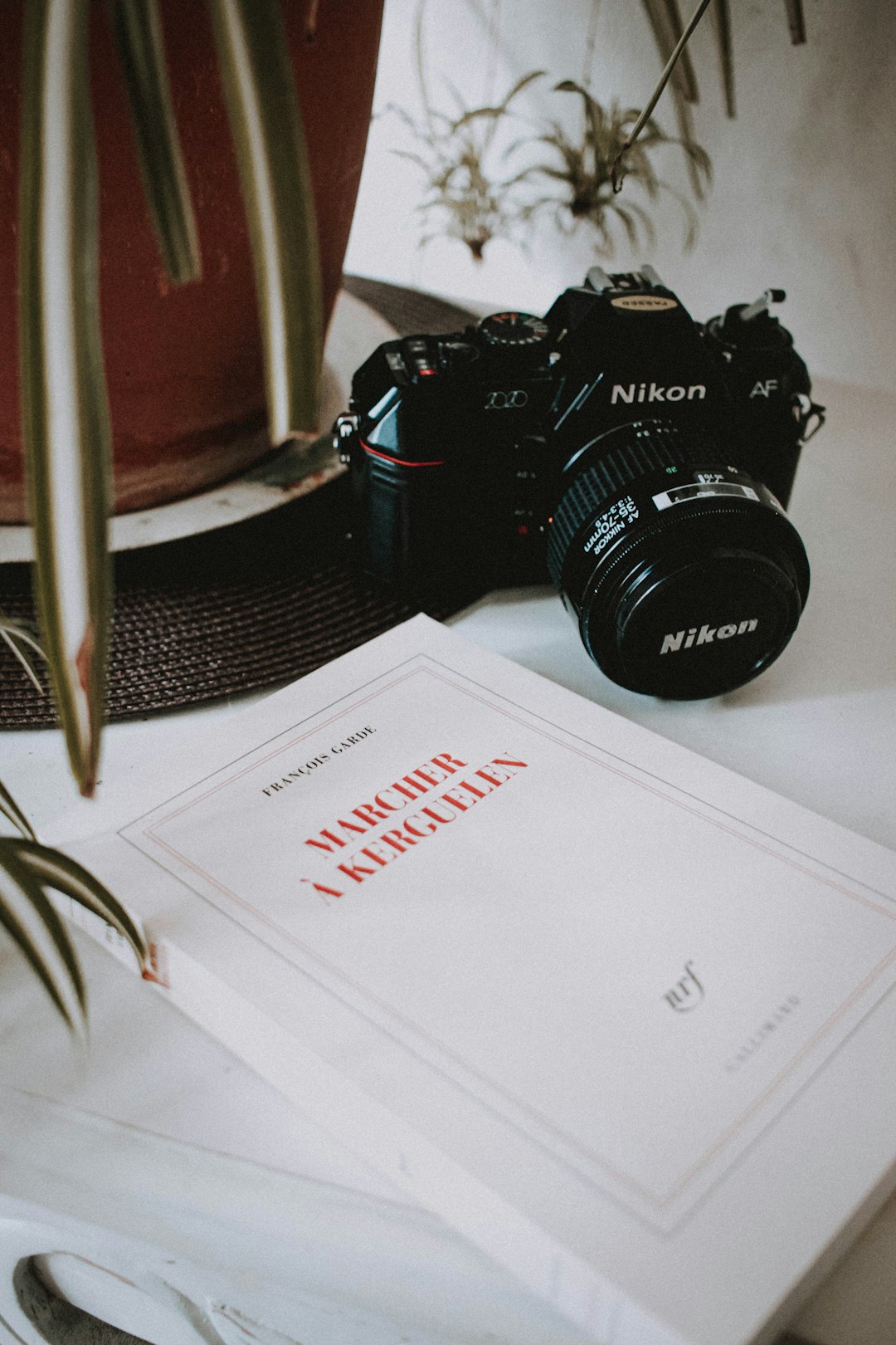 black nikon dslr camera on white paper