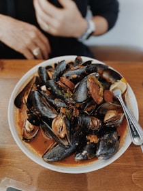 A plate of freshly stuffed mussels garnished with lemon wedges.
