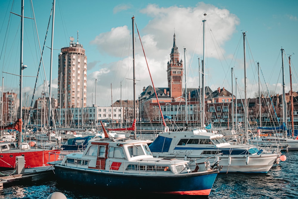 white and red boat on sea near city buildings during daytime