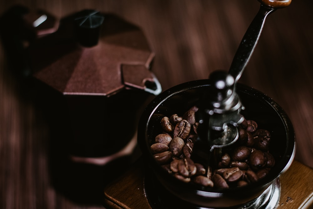 grãos de café em caneca de cerâmica preta