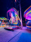 Night event scene with riders under colorful lights and a lively mountain party atmosphere.