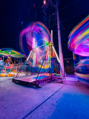 Night event scene with riders under colorful lights and a lively mountain party atmosphere.