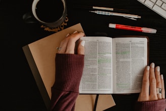 person in maroon long sleeve shirt holding white printer paper