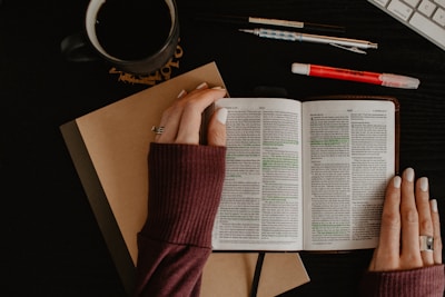 person in maroon long sleeve shirt holding white printer paper