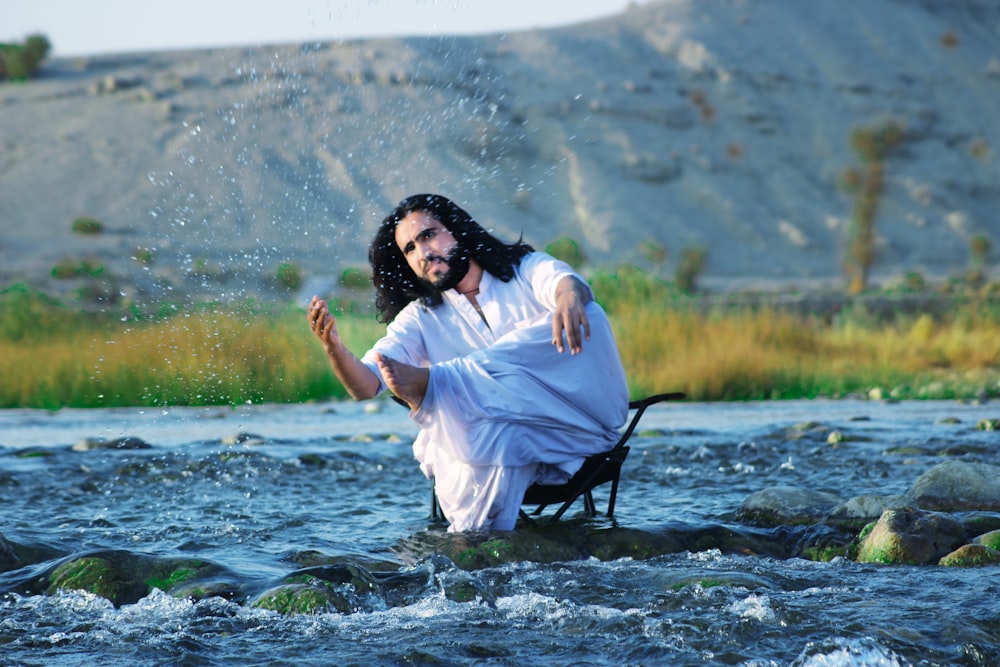 woman in white dress standing on river during daytime