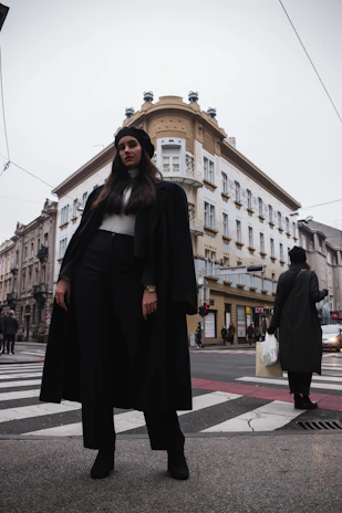 A stylish woman carrying a Luma Devaux tote bag while walking confidently in a city setting.