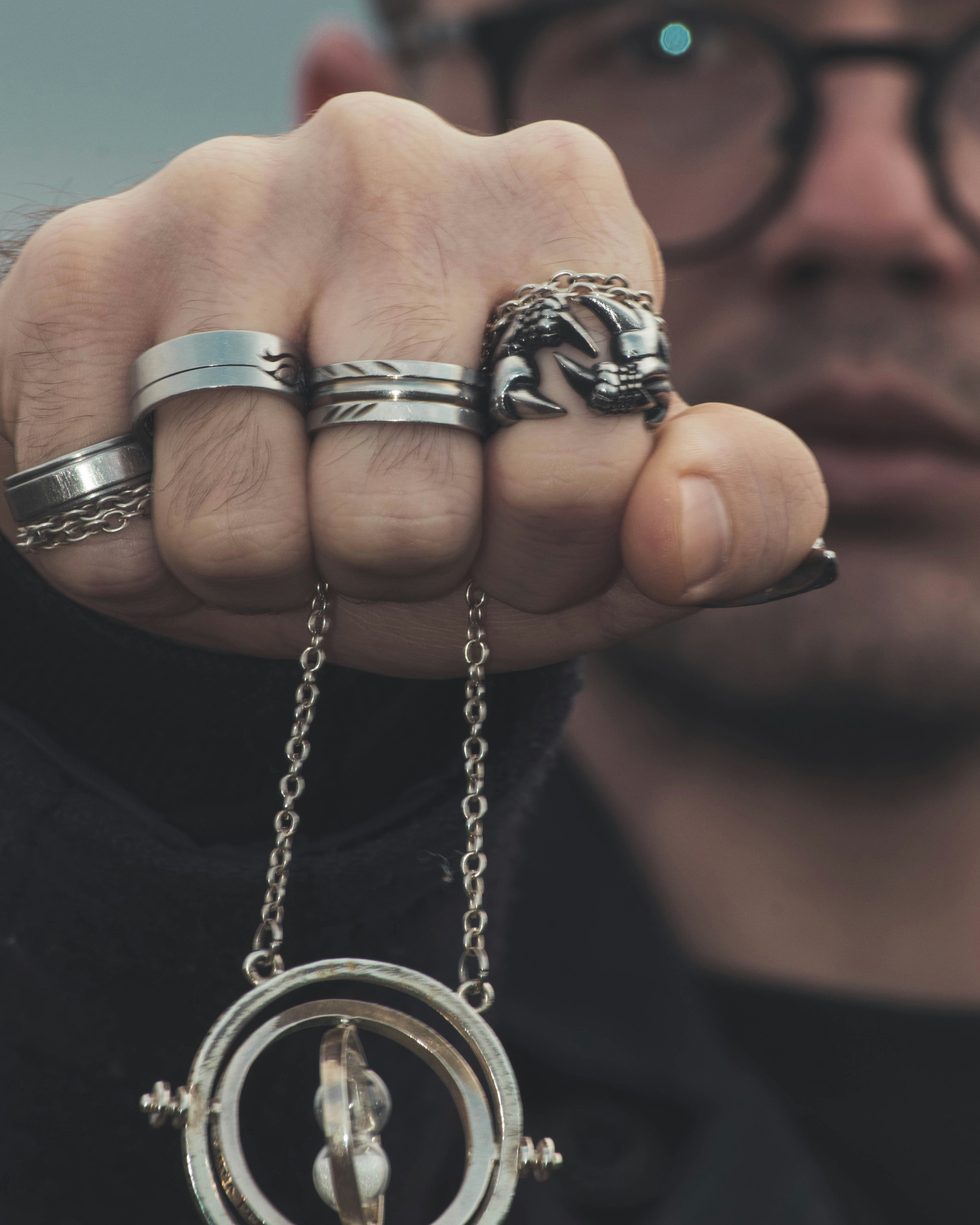 person holding silver and black beaded necklace