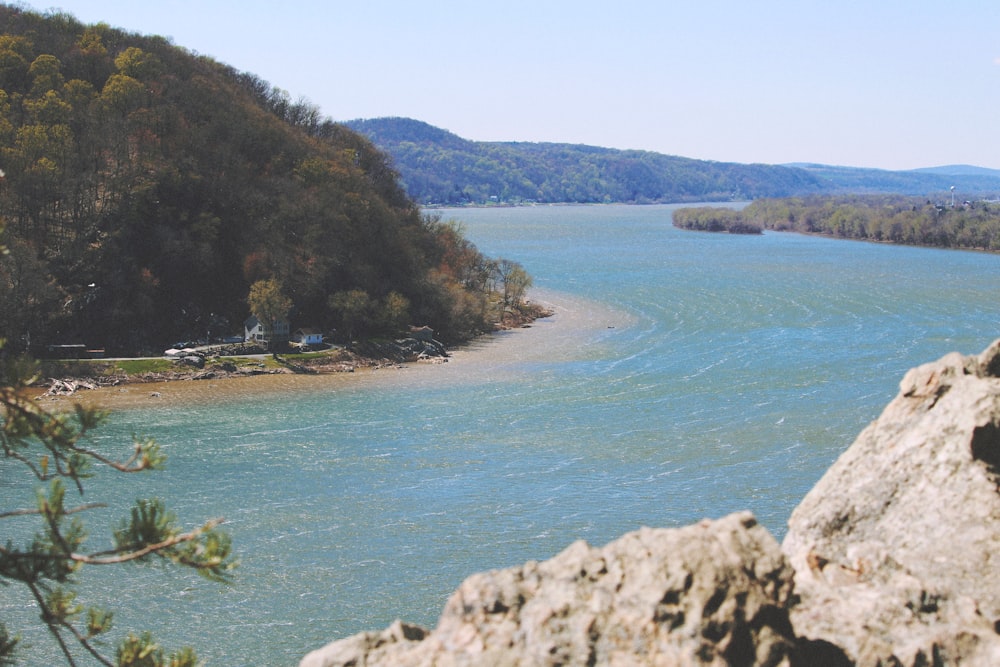 green and brown mountain beside body of water during daytime