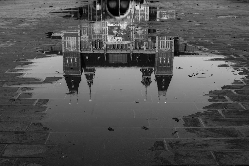 grayscale photo of people walking on wet road