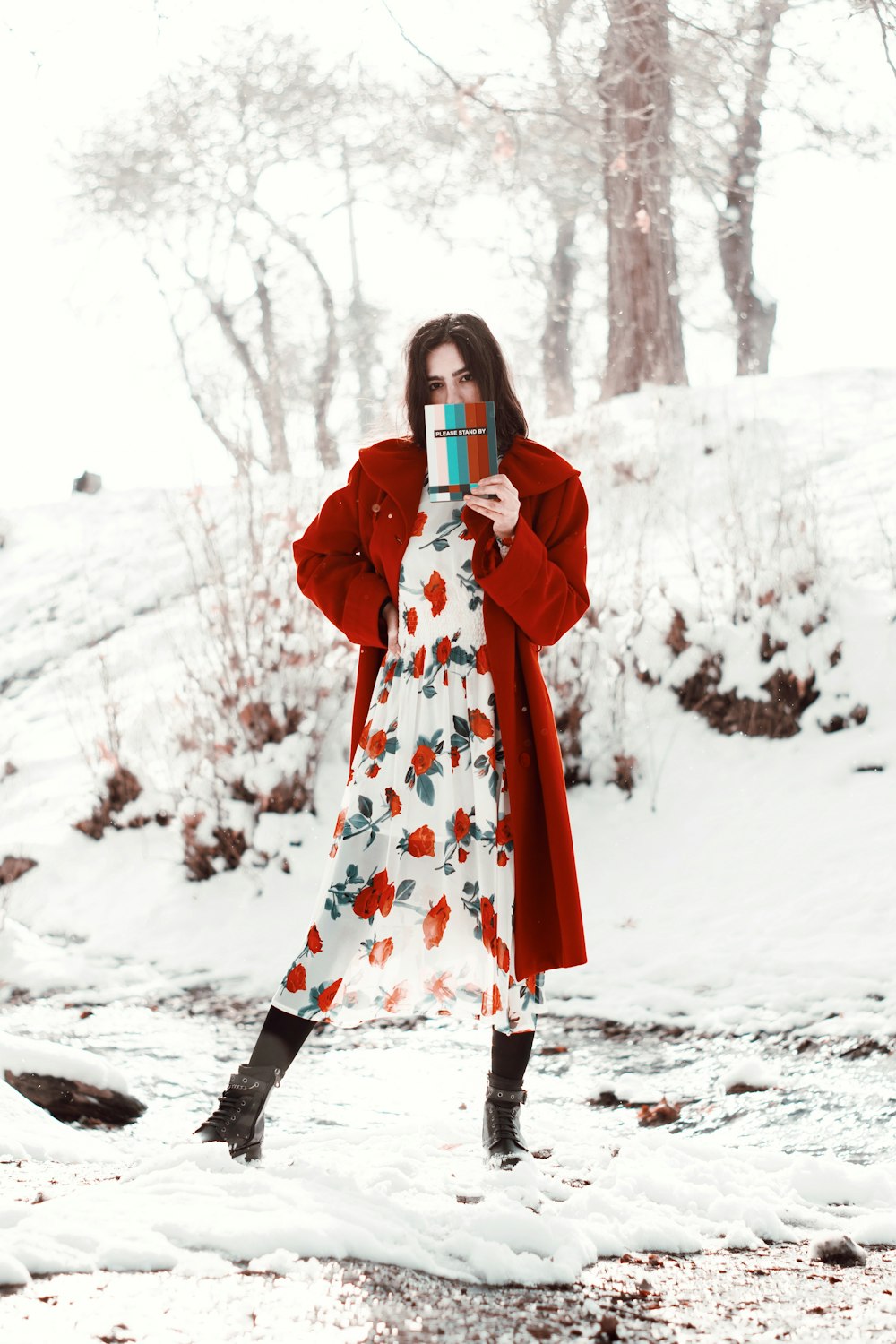 woman in red and white floral robe holding white ceramic mug