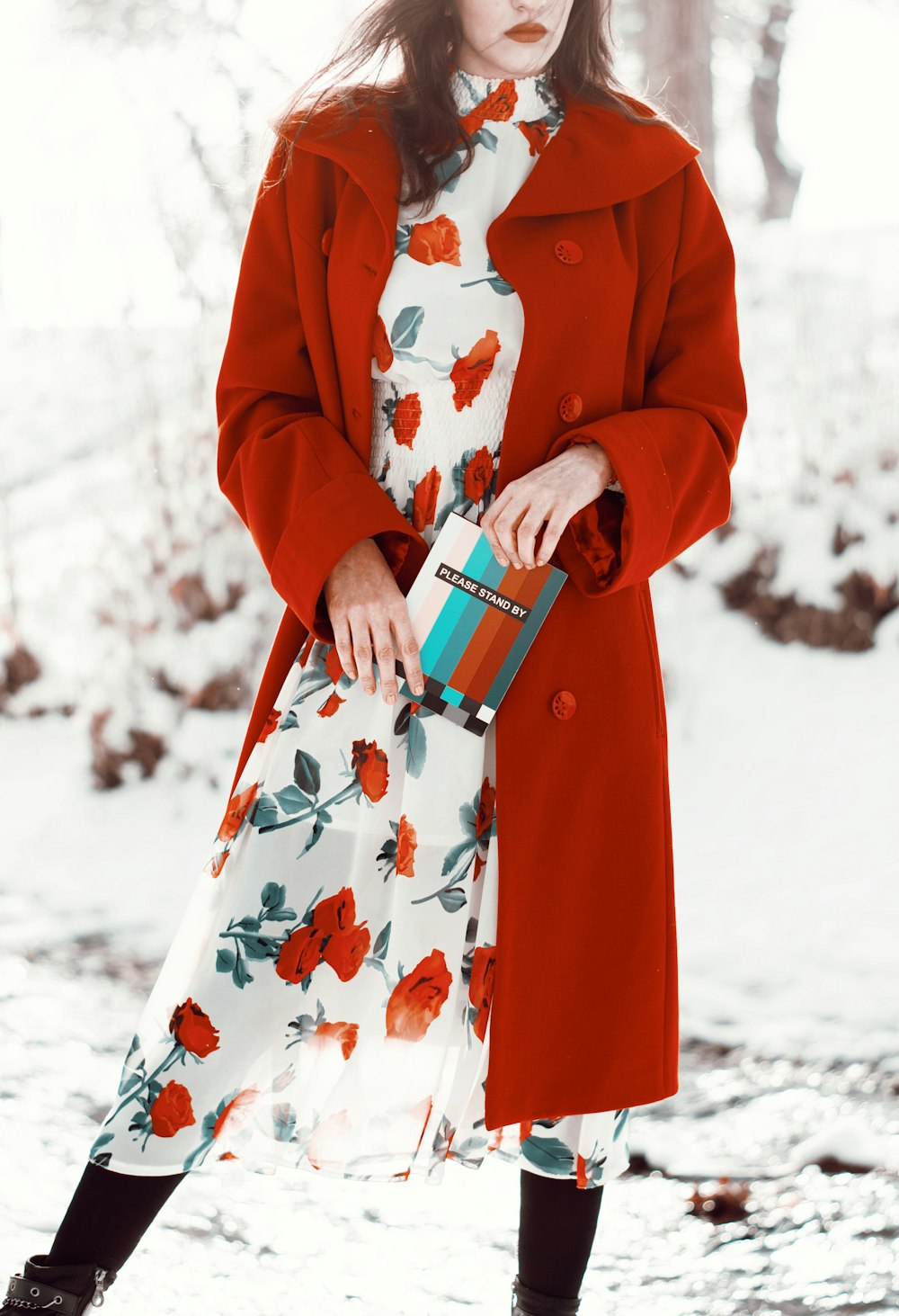 白い陶器のマグカップを持つ赤いコートの女性