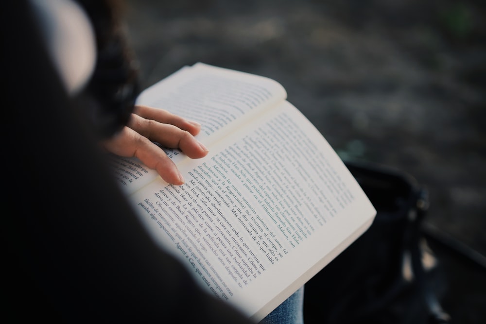 person holding book during daytime