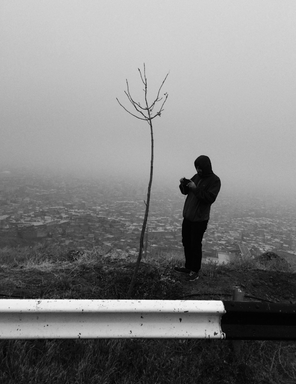 hombre con chaqueta negra de pie en la cima de la colina