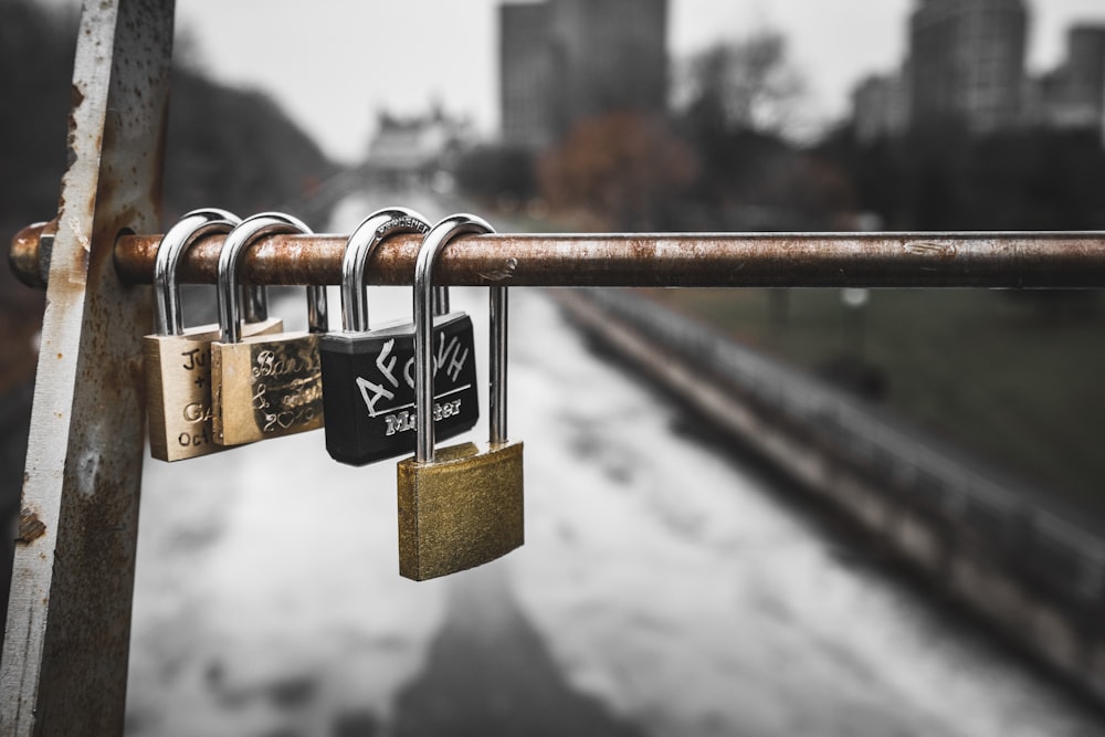 gold padlock on brown metal fence during daytime