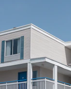 Exterior shot of a vacation rental home with fresh beige paint and blue trim