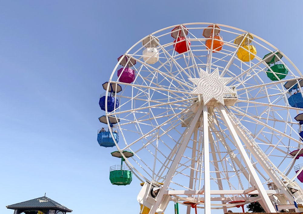 ruota panoramica bianca, rossa e blu sotto il cielo blu durante il giorno