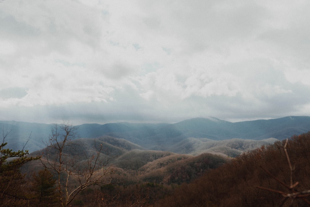 brown and green mountains under white clouds during daytime