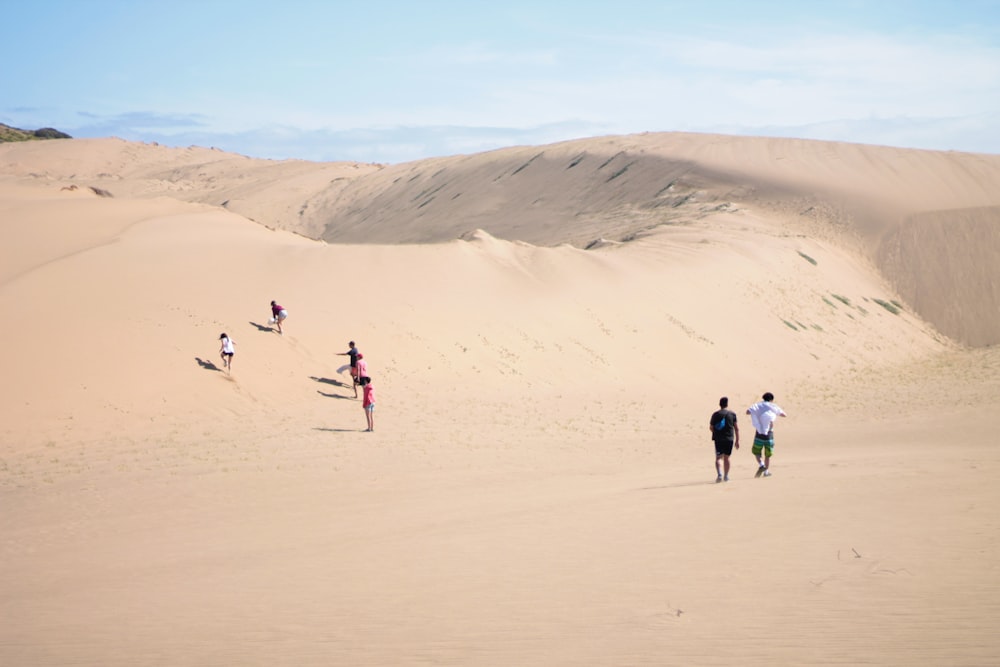 people walking on white sand during daytime